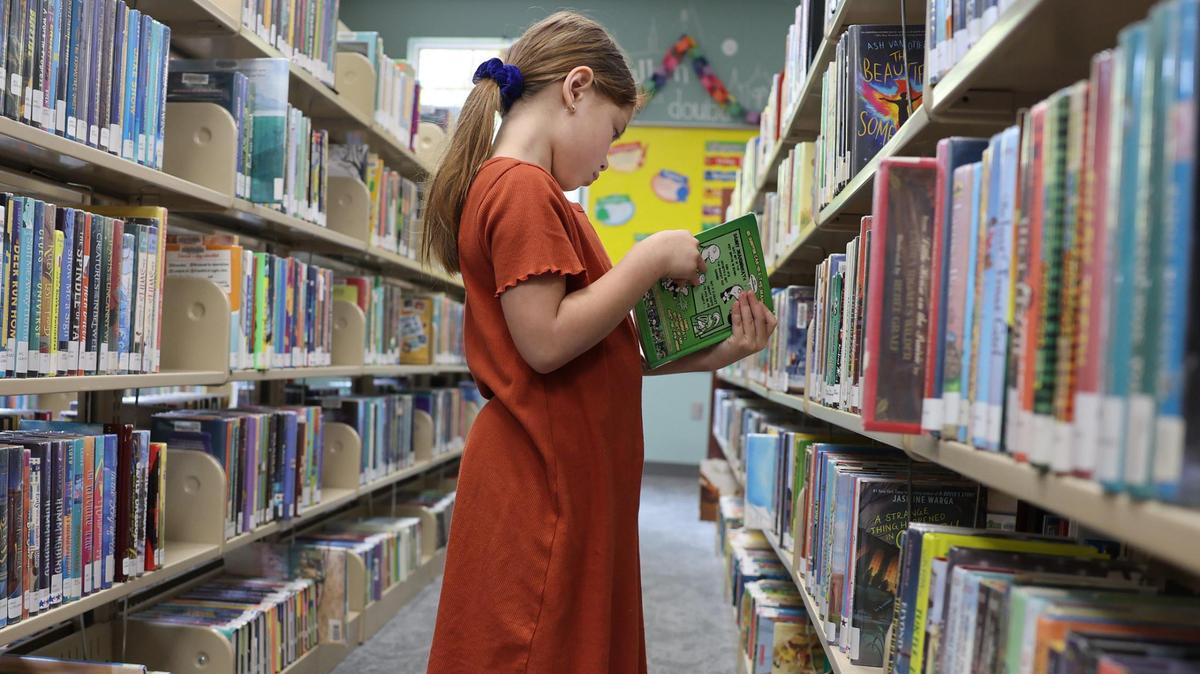 7-year-old Madilyn Hardgrove looks at a book Friday at the Fort Mill Library.