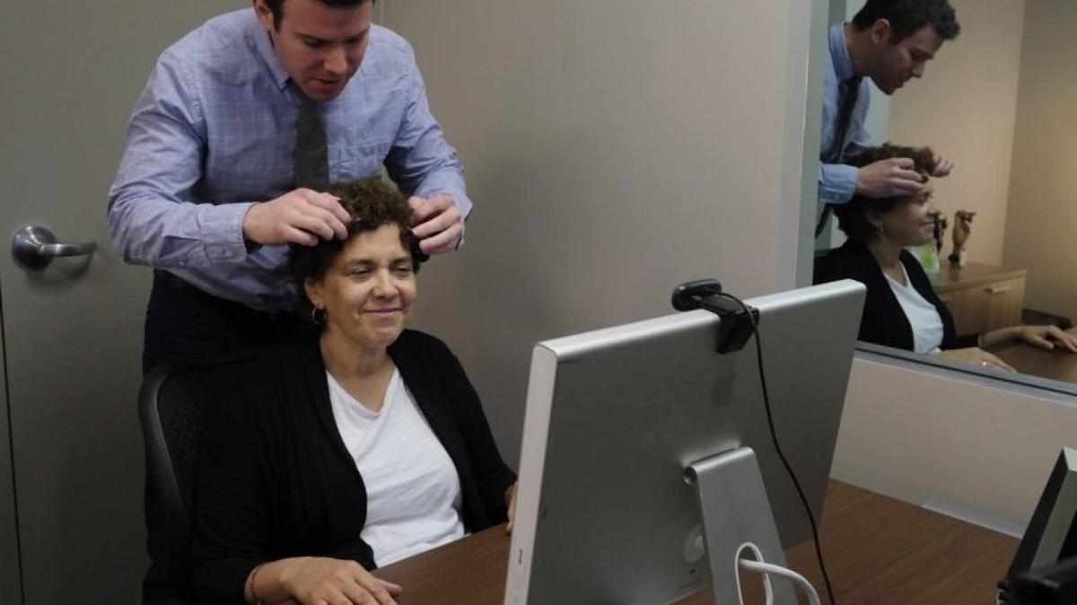 Neuroscientist Ryan McGarry prepares Jennie Litvack, 52, an economist, to participate in research at Spark Experience, a firm that is using EEG, eye tracking and other technologies to record how participants respond to political candidates.