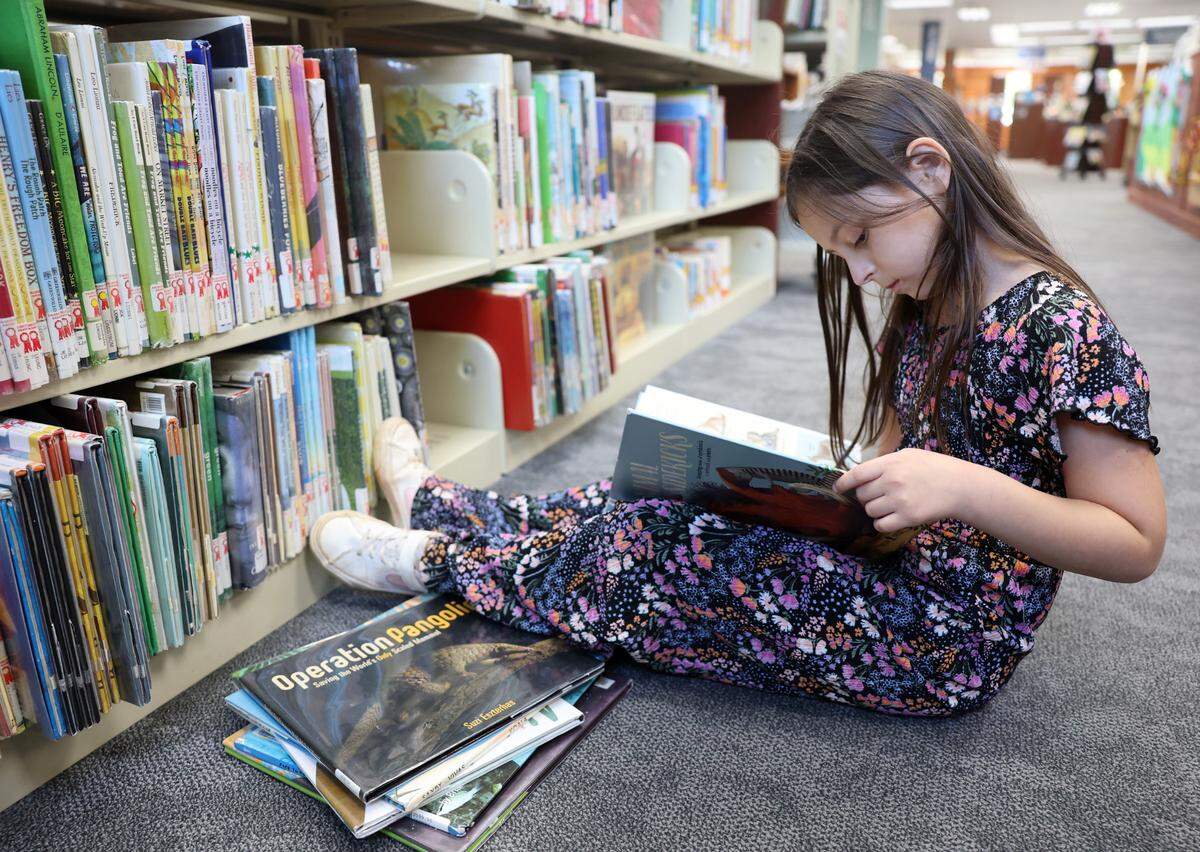 9-year-old Bailey Byers reads a book at the York County Library in Fort Mill.