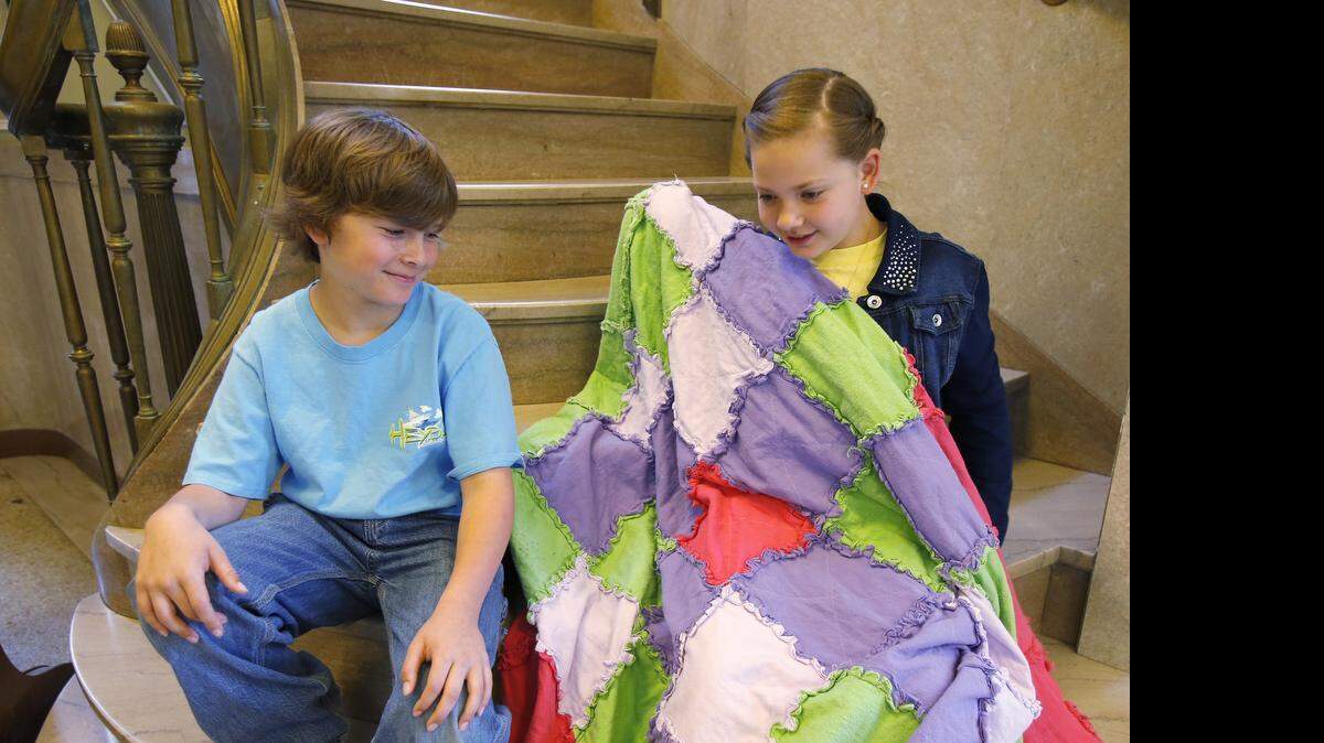 
Kix Reinhardt, 9, left, and his sister Lexi, 11, look at the quilt Lexi made at 4-H camp in Chester County.
