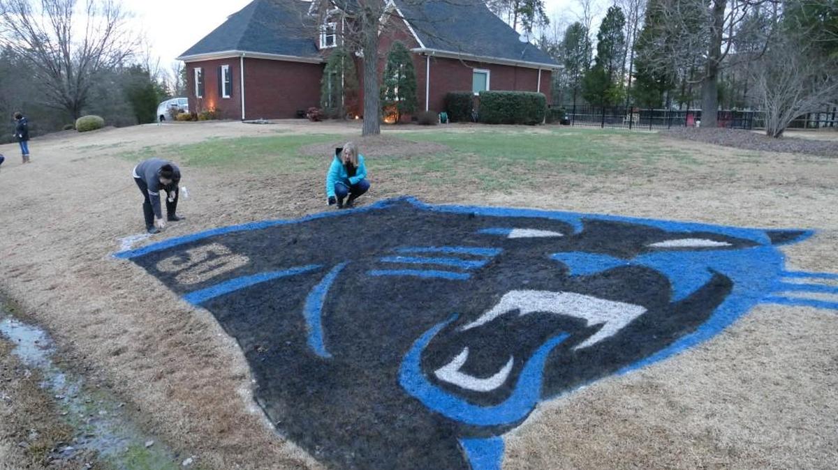 Katey Parham, left, and Lisa Clark put the finishing touches on the Panthers logo they spray painted in a neighbor’s front yard on Clearview Road in Rock Hill on Saturday.