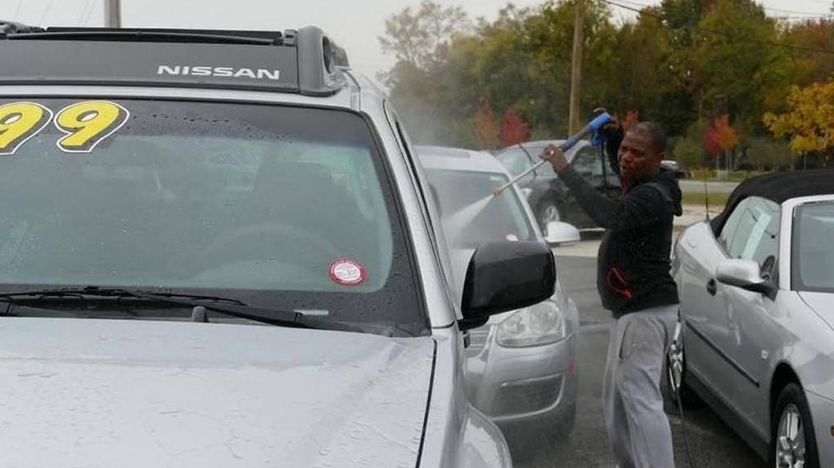 Arnold Reid hoses down a car for sale at M&M Motors on Cherry Road. One of 45 car dealerships in Rock Hill, M&M could be affected by new rules being crafted by city planners.