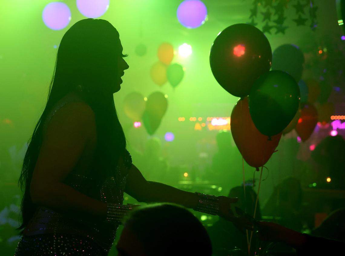 Drag queen Victoria Lefaris accepts money from a fan at a drag show on New Year's Eve.