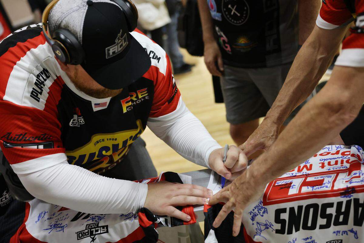 Jamie Graham signs an autograph Friday at the American Cornhole League’s World Championships in Rock Hill, S.C.