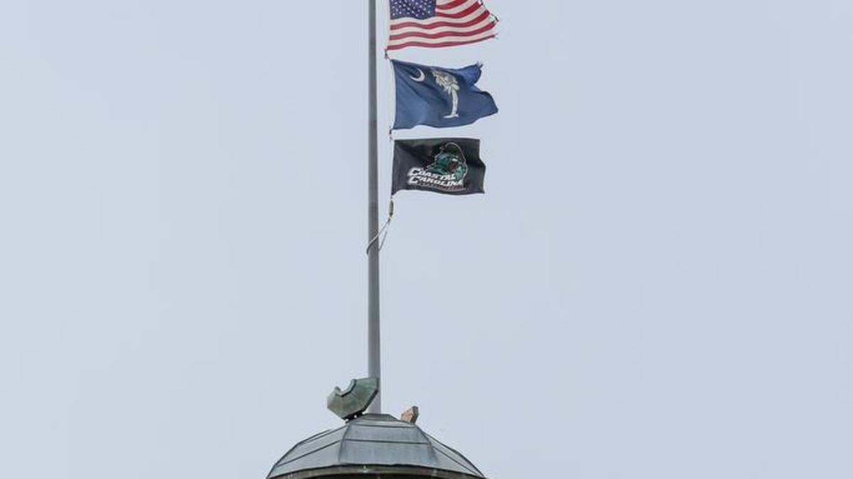 The Coastal Carolina flag is hoisted up the flagpole on the South Carolina State House after the Chanticleers beat Arizona to win the 2016 NCAA National Baseball Championship.