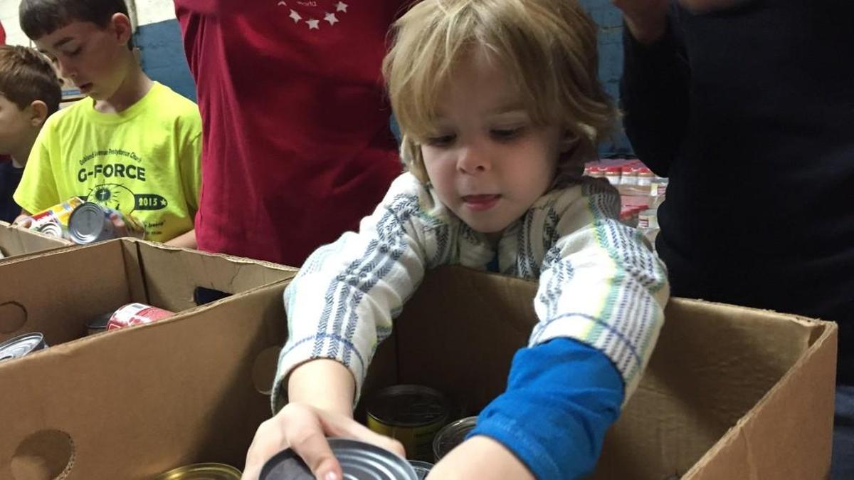 Sullivan Elder, 5, helps sort food for Project Hope. The Rock Hill crisis assistance agency is collecting food for students on spring break.