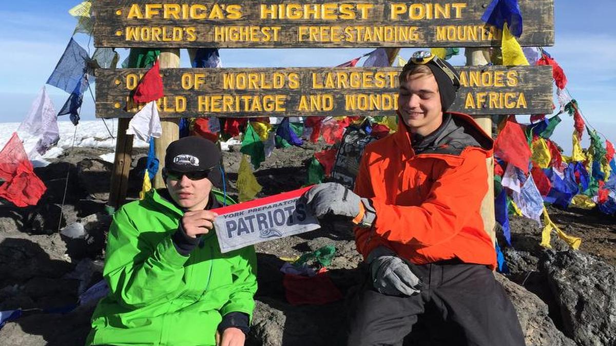 Carter Craze, left, and Jared Johansen display a homemade York Preparatory Academy flag at Uhuru Peak, the summit of Mount Kilimanjaro.