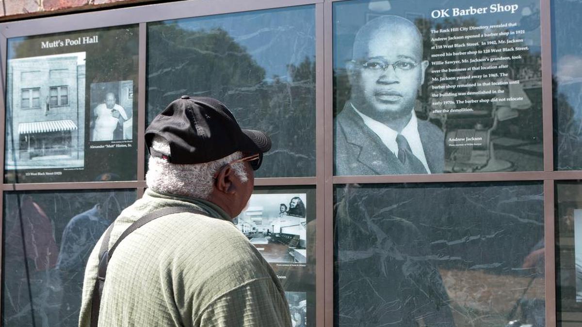 
Murray L Smith looks at a photo of Andrew Jackson of the OK Barber shop and reminisces about the hair cuts he had there during the African-American Business District Exhibit Dedication Ceremony.
