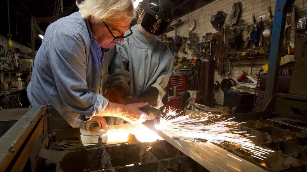 Artist Bob Doster helps 15-year-old Lancaster High student Emily Tindal cut a metal shape.