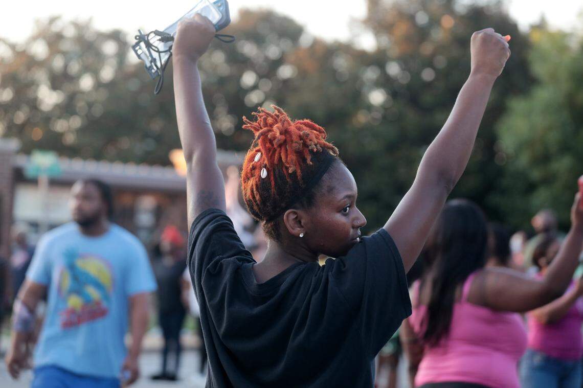 A protester raises her arms Wednesday during a protest in downtown Rock Hill.