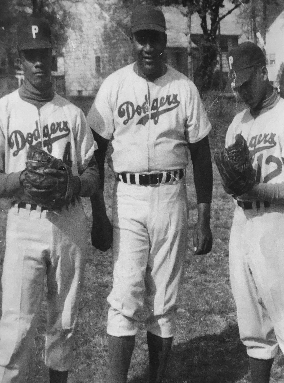 From left, Wali Catchcart, coach Herman Hicks and Lindward Cathcart pose for a photo in 1959.