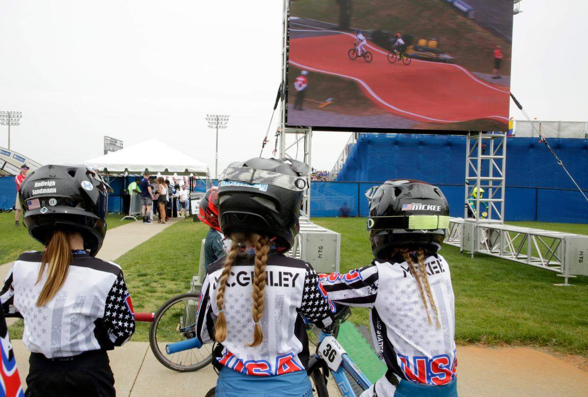 Irelyn McGinley, middle, watches the BMX races from a large screen Monday at the BMX World Championships in Rock Hill.