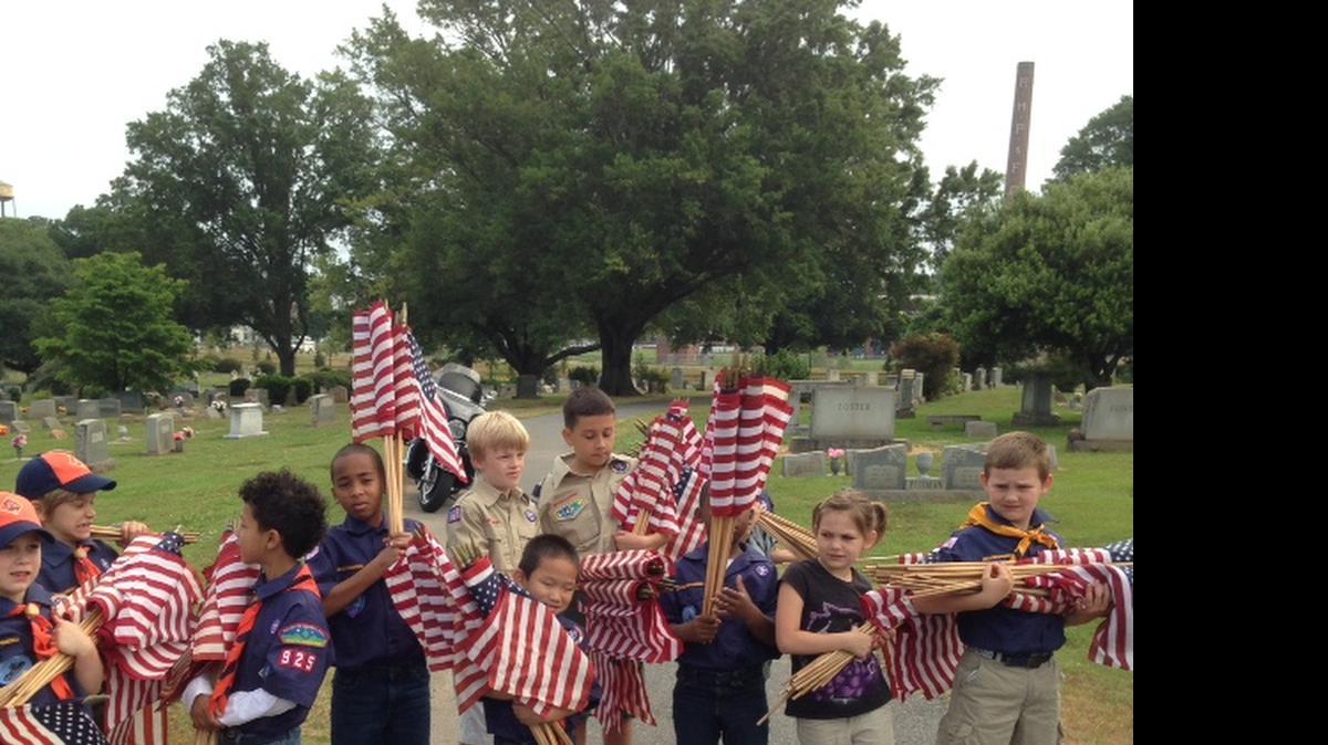 
Members of Scout Pack 925 load up on flags before they fan out around Laurelwood cemetery on Sunday. The elementary school-aged Scouts helped the American Legion place hundreds of flags on veterans’ graves ahead of Memorial Day.
