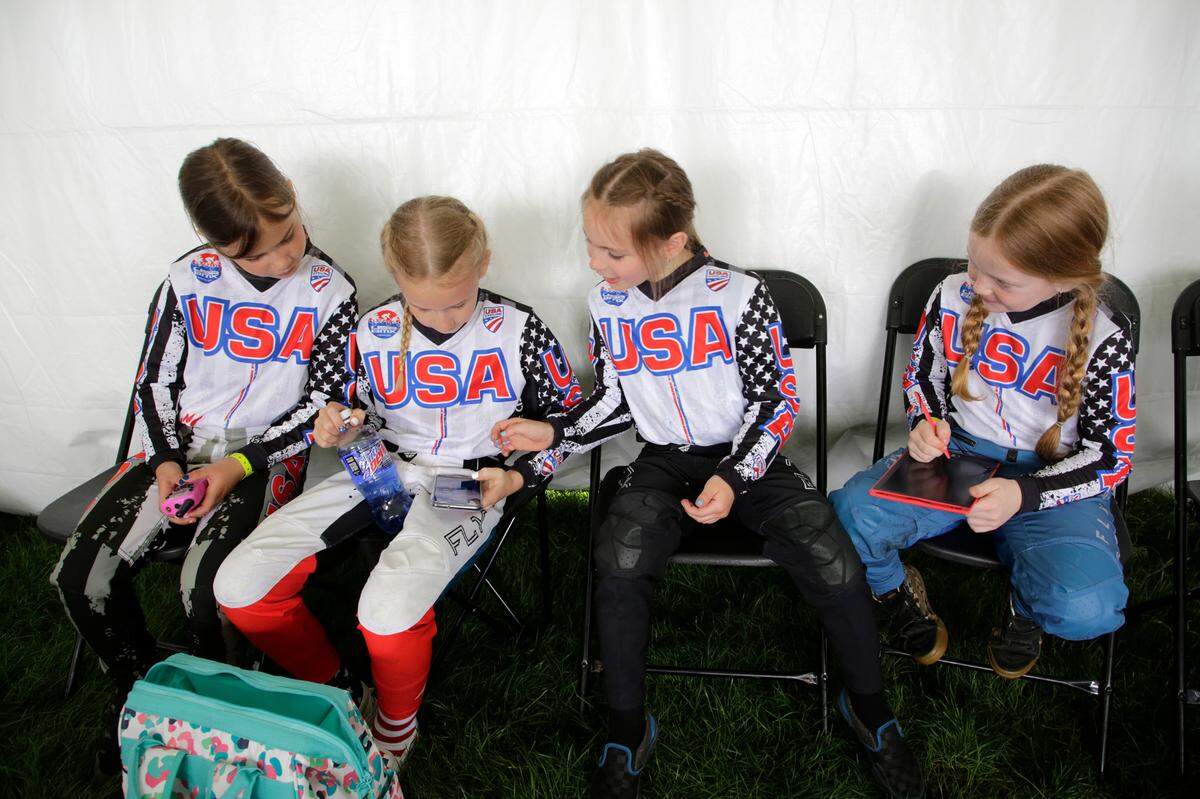 Irelyn McGinley, right, and her teammates chat before competing Monday at the BMX World Championships in Rock Hill.