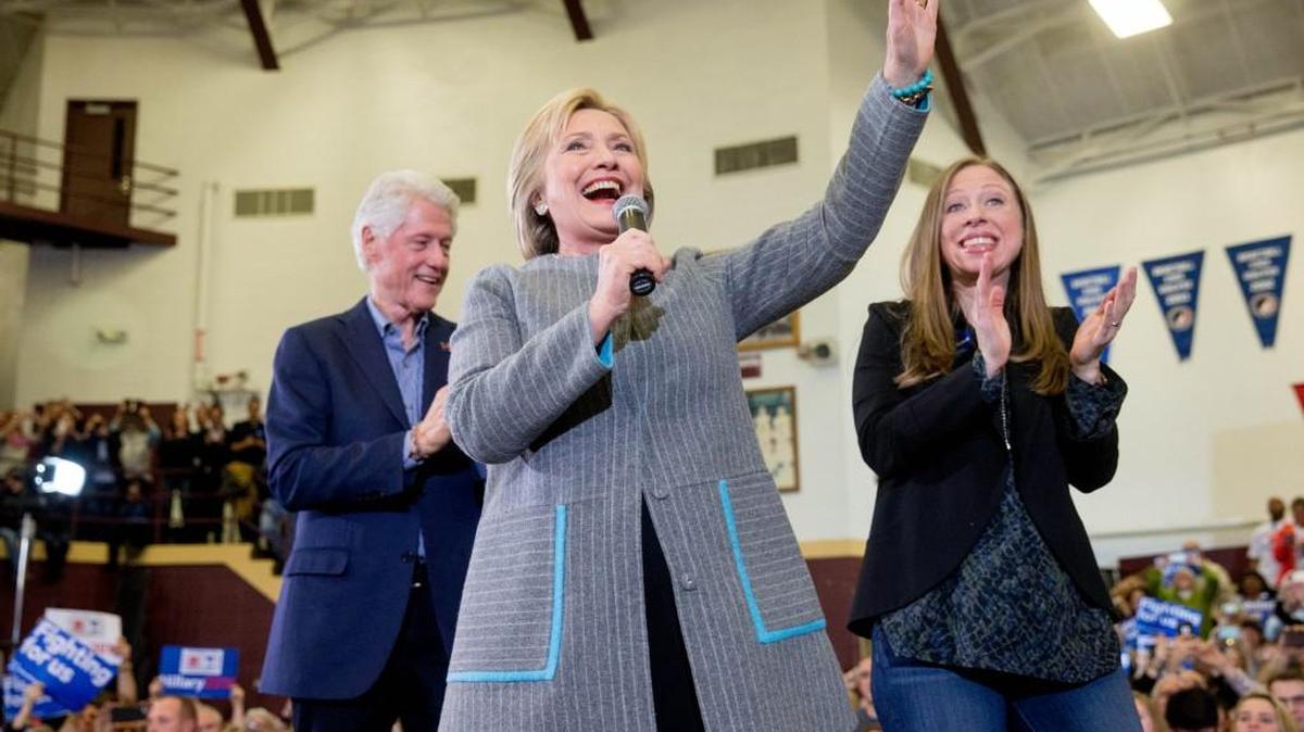 Democratic presidential candidate Hillary Clinton, accompanied by her husband, former President Bill Clinton and their daughter Chelsea Clinton, waves as she arrives to speak at a rally at Abraham Lincoln High School in Des Moines, Iowa, on Sunday.