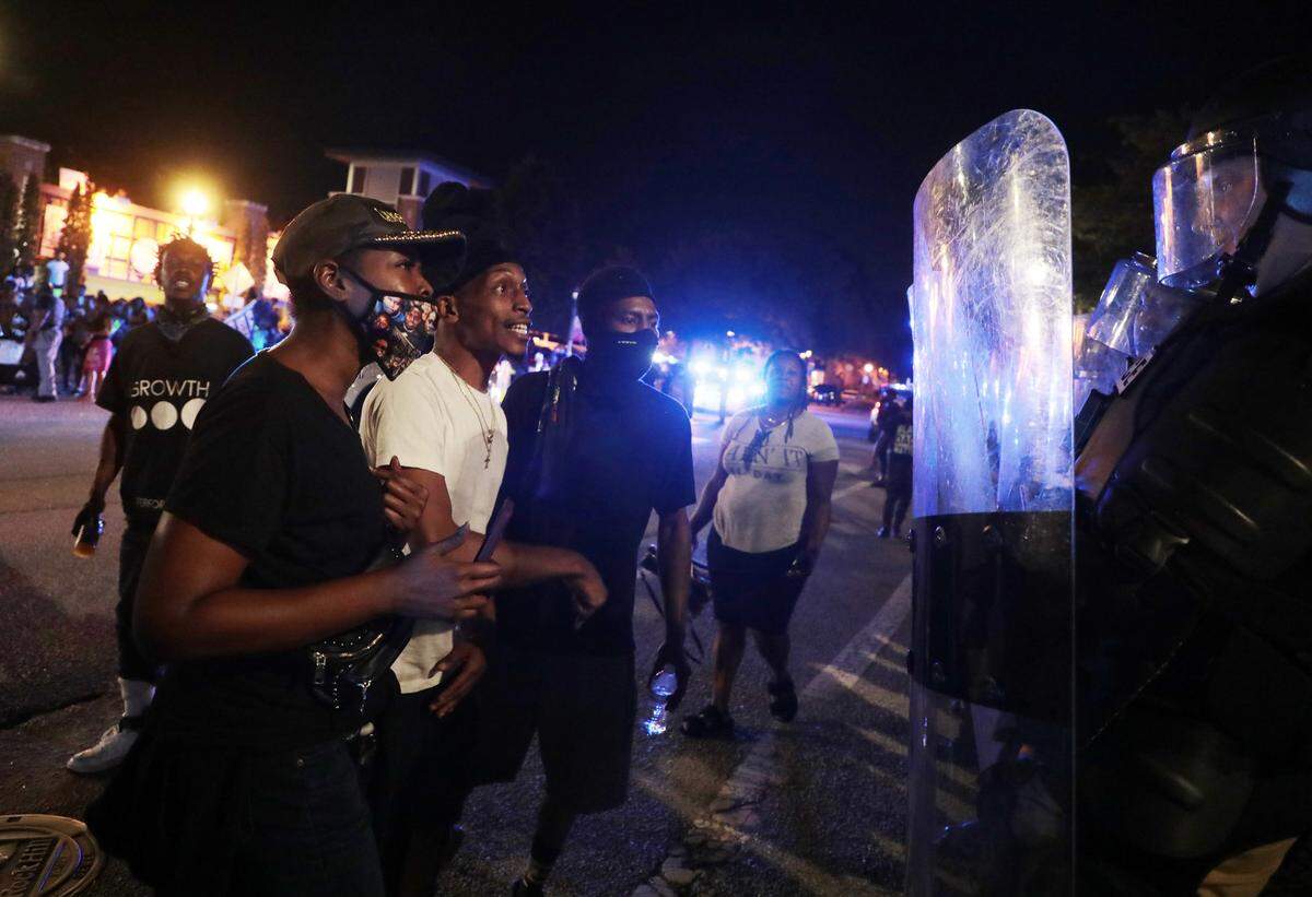 Protesters confront police officers in riot gear during protests in 2021 that followed the arrests of Ricky and Travis Price.