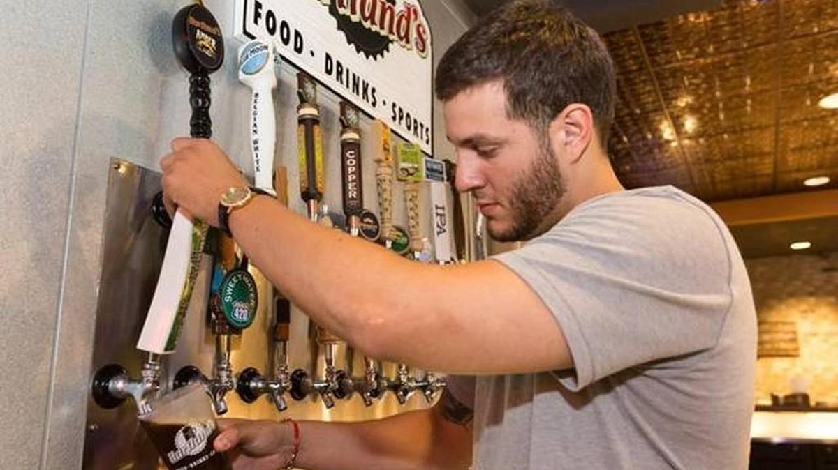 Bar manager Thomas Perez pours a brown ale at Hartland’s Sports Bar in Rock Hill.
