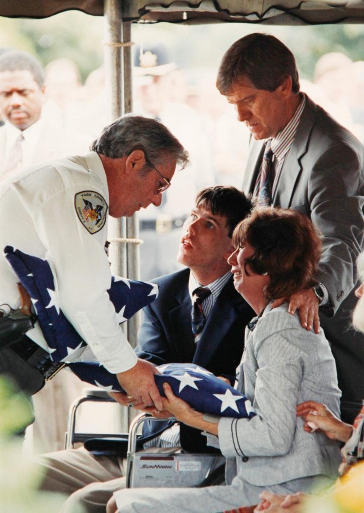 Then-York County Sheriff George Eaton presents the American flag from Deputy Brent McCants’ casket to his mother, Myra McCants, during the funeral on Sept. 28, 1992 in Lancaster. She is comforted by her brother Bill Estridge, right, and her son Billy Dale McCants.