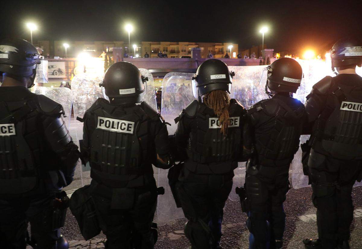 Police officers in riot gear stand in line in front of the Rock Hill Police Department Thursday night.