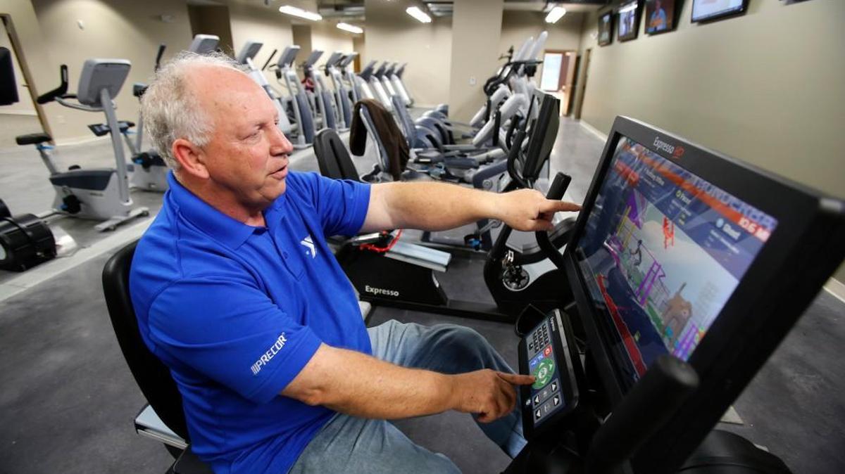 Moe Bell, CEO of the Upper Palmetto YMCA, demonstrates an Expresso recumbent bike at the new Riverwalk YMCA.