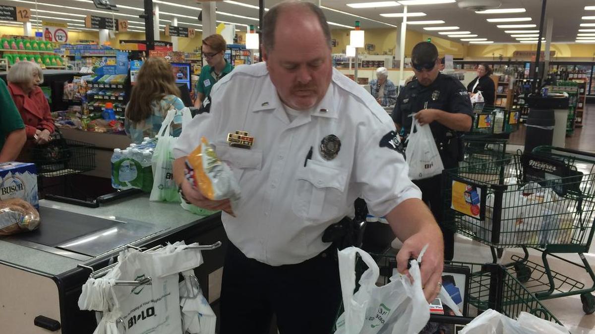 York Police Lt. Dale Edwards helped customers load groceries last month at Bi-Lo.