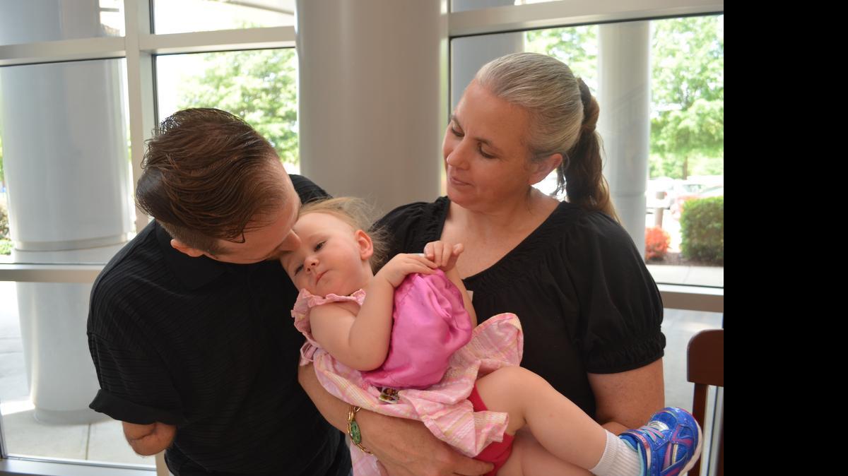 
David Wayne Punkett of Rock Hill kissed his 18-month-old daughter Catherline, held by his wie Chelsea. A lawn mower explosion nearly killed Punkett in April. On Thursday Punkett came to Piedmont Medical Center to save thanks to those who saved his life. 
