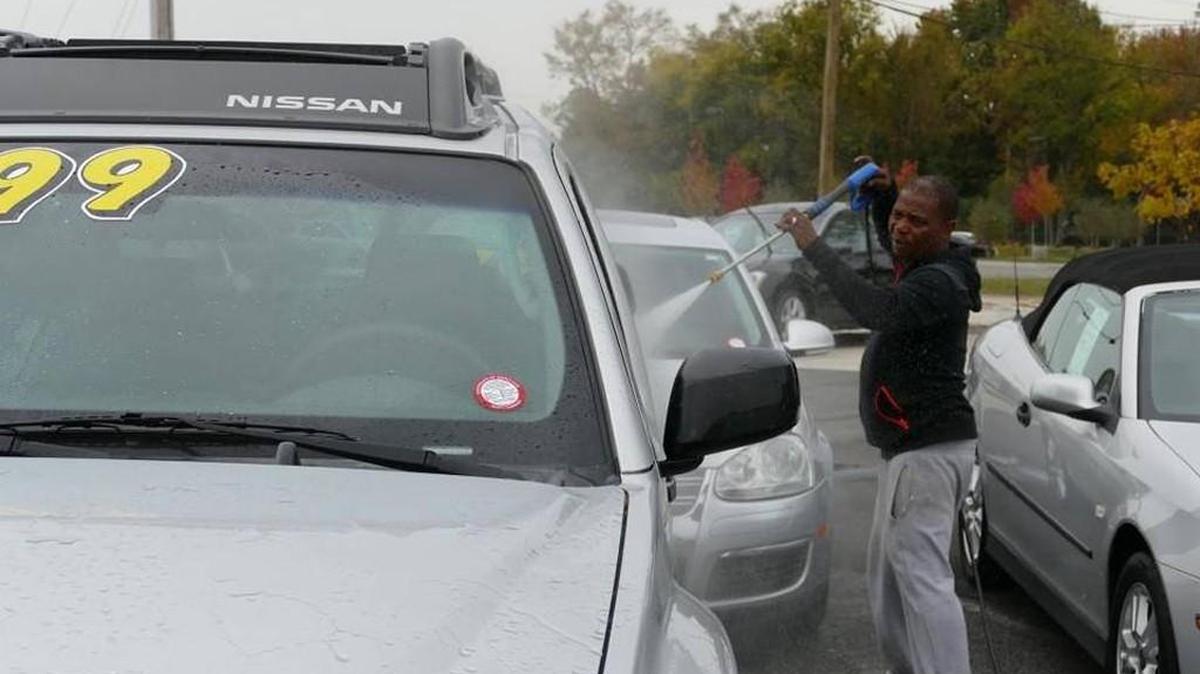 Arnold Reid hoses down a car for sale at M&M Motors on Cherry Road. One of 45 car dealerships in Rock Hill, M&M could be affected by new rules being crafted by city planners.