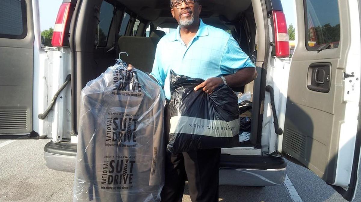 Tim Cureton, an intervention specialist with Lancaster Fatherhood Project, unloads suits donated through a suit drive in 2014.