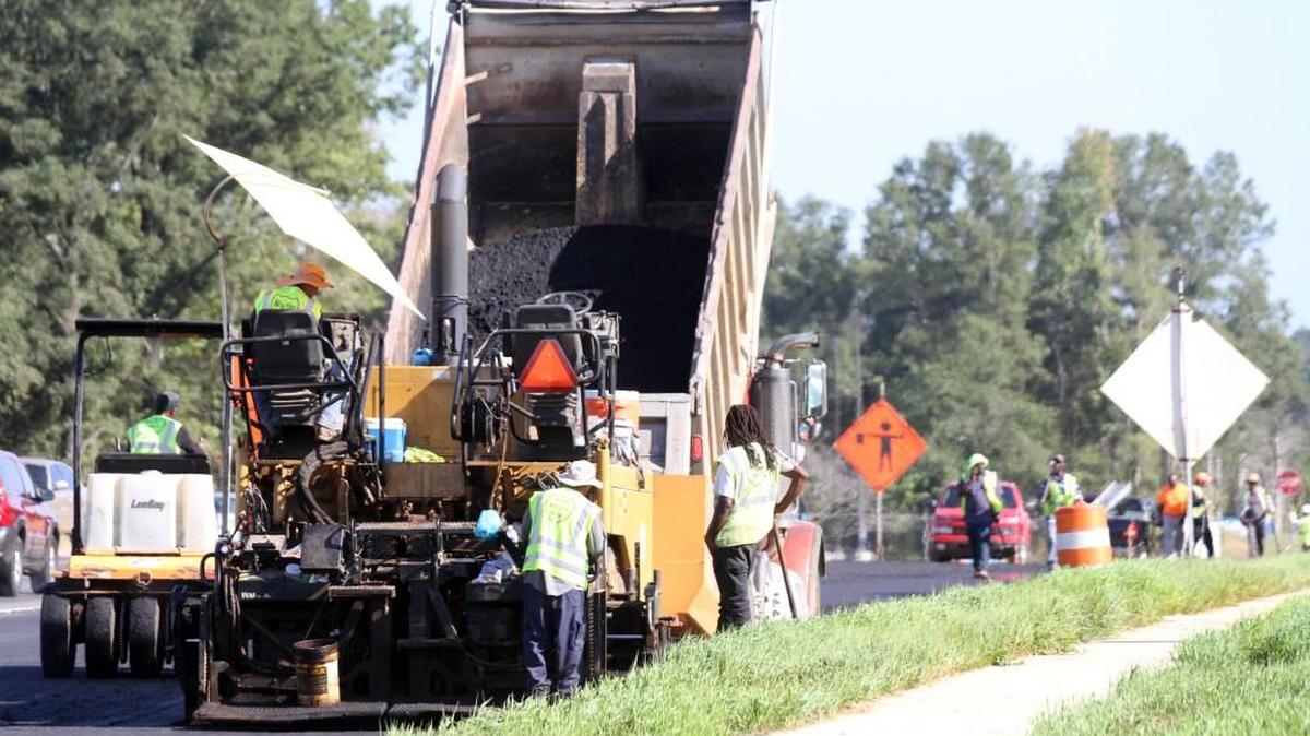 A road crew pours asphalt Wednesday at Cherry and Riverview roads in Rock Hill as part of York County’s Pennies for Progress program.