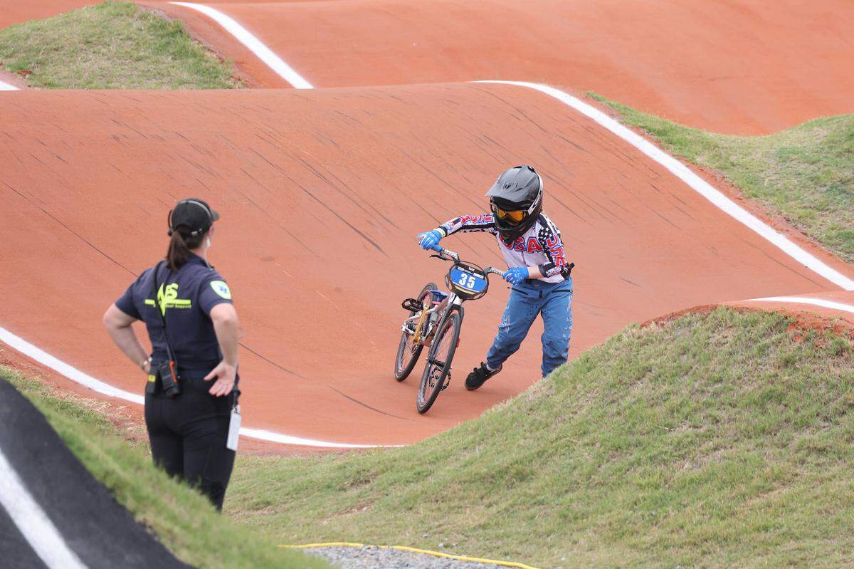 Irelyn McGinley walks with her bike on the track after falling Monday at the BMX World Championships in Rock Hill.