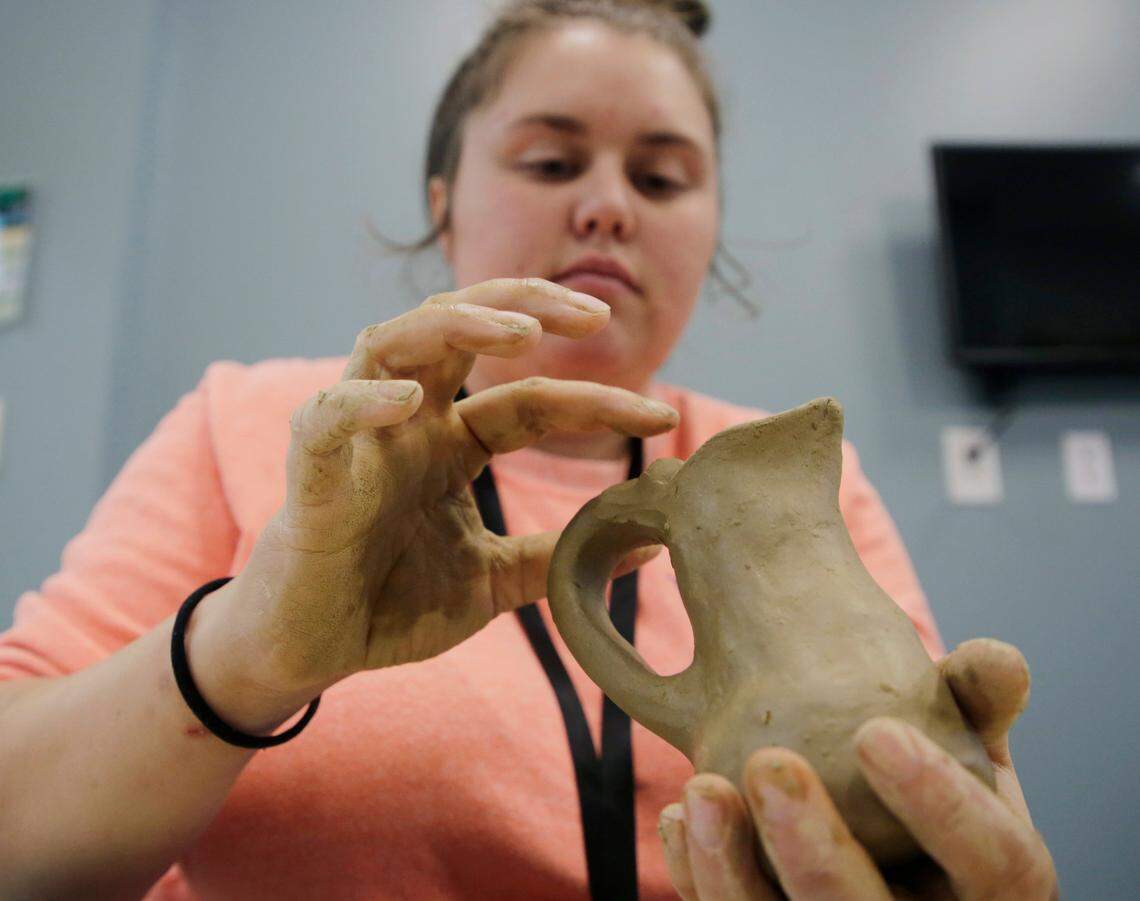 Cheyenne Sanders molds a pitcher with clay Friday at the Catawba Reservation’s Senior Center.