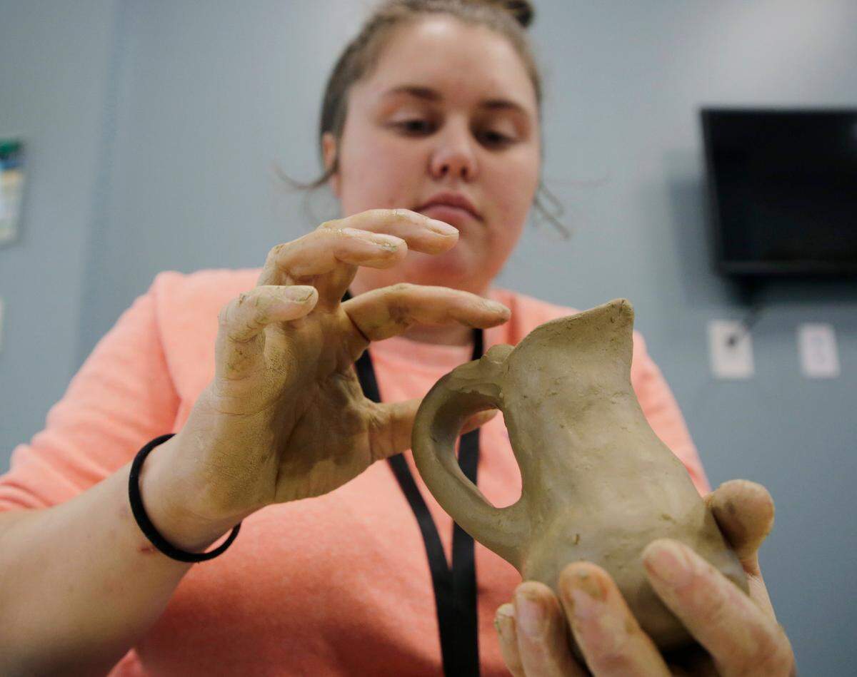 Cheyenne Sanders molds a pitcher with clay Friday at the Catawba Reservation’s Senior Center.