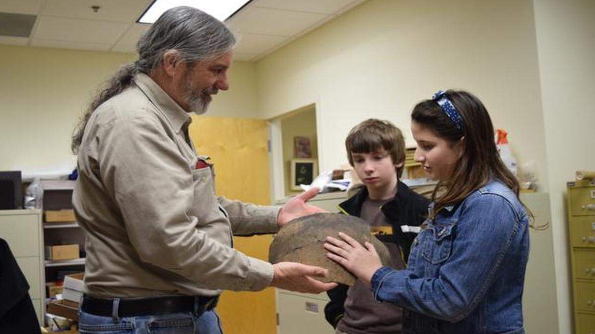 
Archaeologist Chris Judge, the assistant director of the Native American Studies Center, shows Indian Land Middle School students James Bender and Angela Rodriguez a large piece of pottery in the labs of the center.
