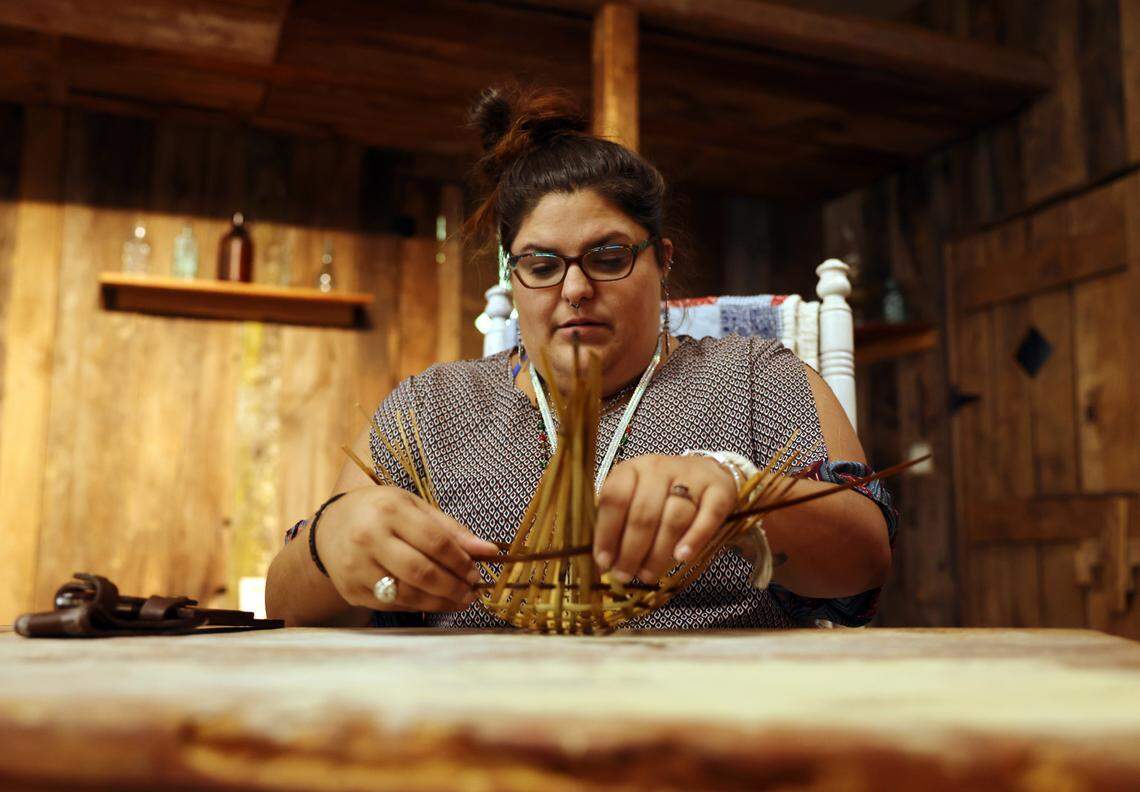 Cassidy Plyler, cultural programs docent and exhibit coordinator at the Catawba Indian Nation, weaves a basket using river cane.