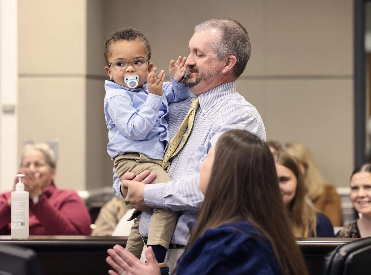 2-year-old Billy Farmer and mother Kendal Farmer clap as John Farmer holds the toddler Wednesday at York County Family Court, where the couple legally adopted him.