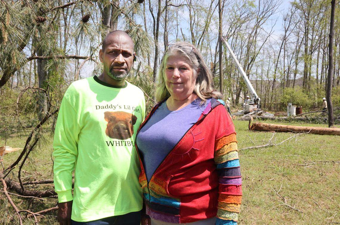 Whitney Long and Elizabeth Long stand in their neighborhs backyard where crews worked to restore power. The Longs lost power during the hail storm Saturday.