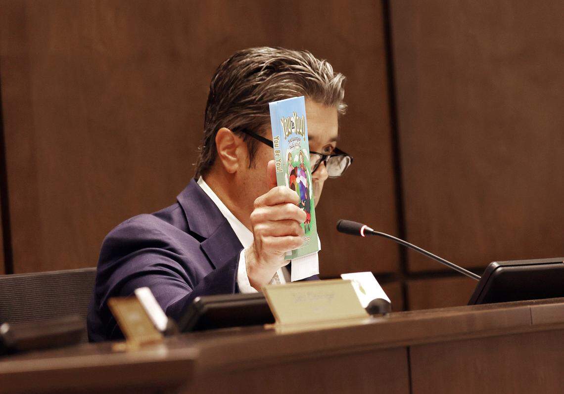 York County Councilman Tom Audette shows a children’s book to a crowd at Monday’s meeting in York.