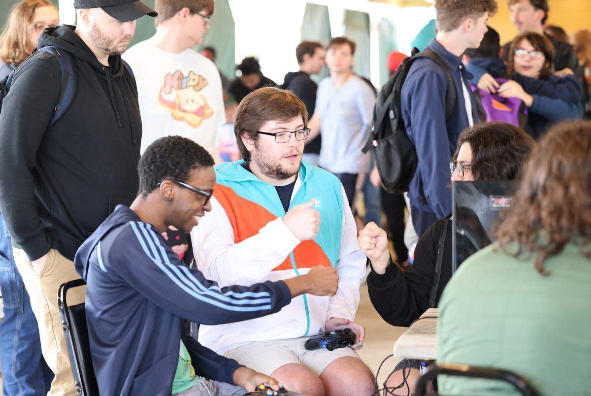 Gamers at the Rock the Winds esports tournament fist bump after winning a game Saturday at Carowinds.