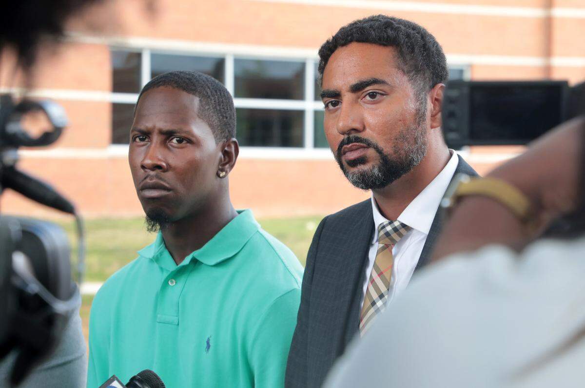 Travis Price, left, and his attorney Justin Bamberg listen during a press conference outside Moss Justice Center. Charges were dropped against Travis Price.