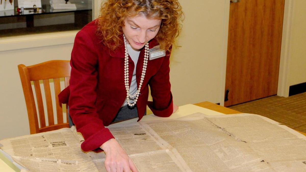 Nancy Sambets, archivist with the Historical Center of York County in York, looks at an early copy of the Yorkville Enquirer.