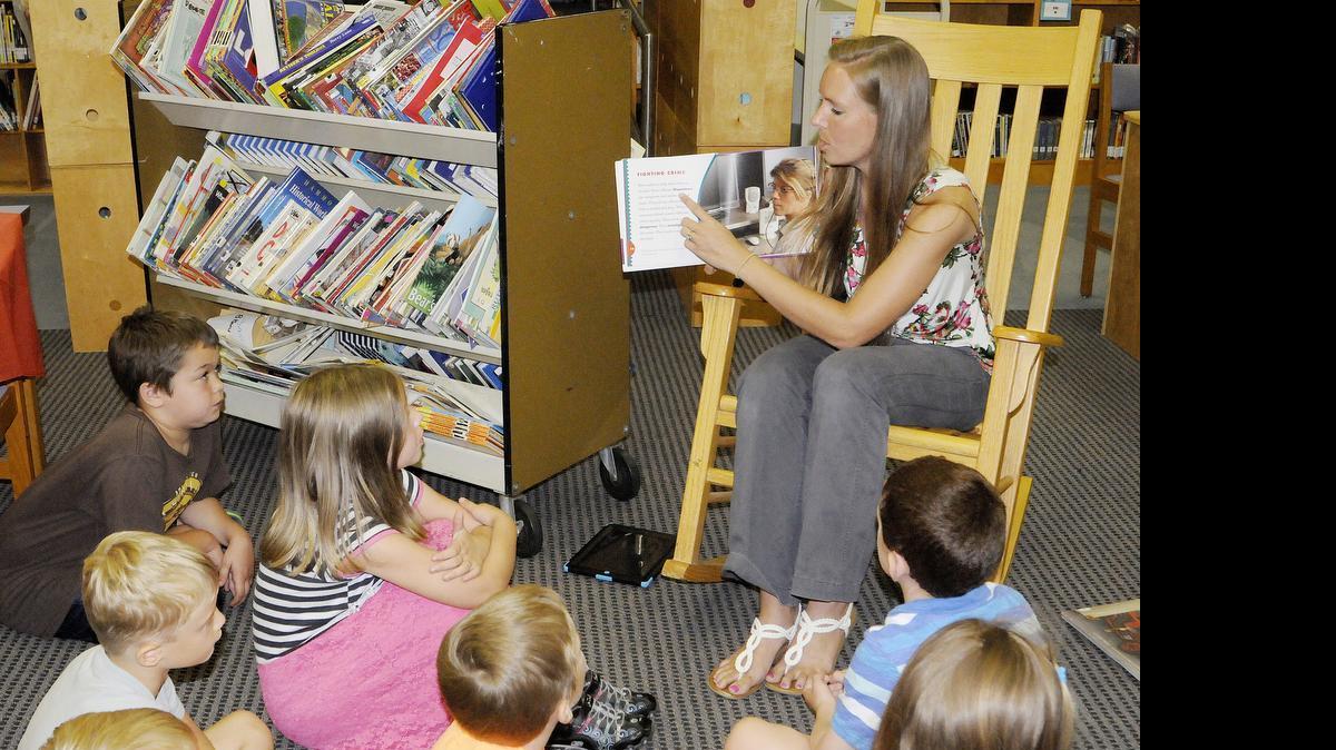 
Rebecca Crute reads a book about police officers to students in the Kinard Elementary School summer reading program.
