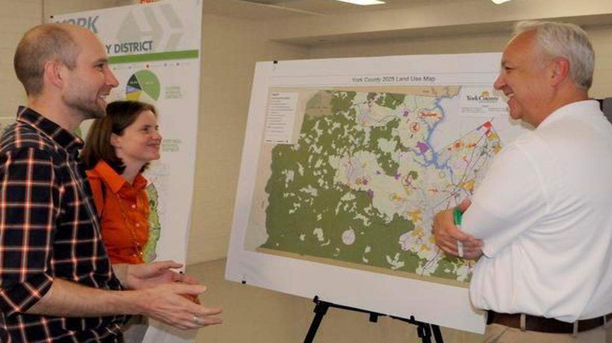 
Emily Powell, left, and Andy Rathke, right, both planning and development managers with Walton Development and Management, talk with land design consultant Jake Petrosky, center, during an open house in York Thursday night on York County’s long-range planning.
