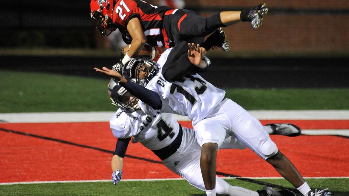 Clover’s Terion Hubert, center, and Chase Hill, left, keep Nation Ford’s Tyree Chaplin one yard from the end zone early in the first quarter Friday night. The Falcons scored on the following play.