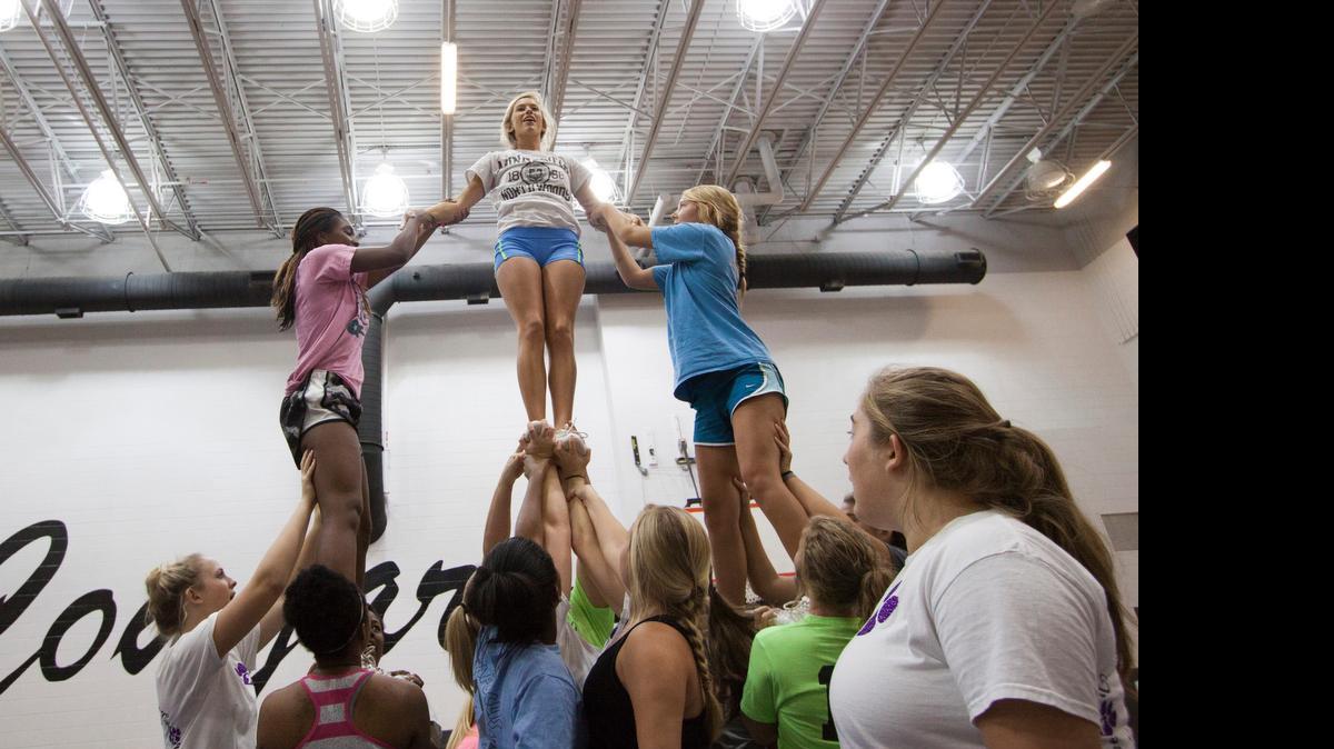 
York Comprehensive High School varsity cheerleaders perform a stunt during practice.
