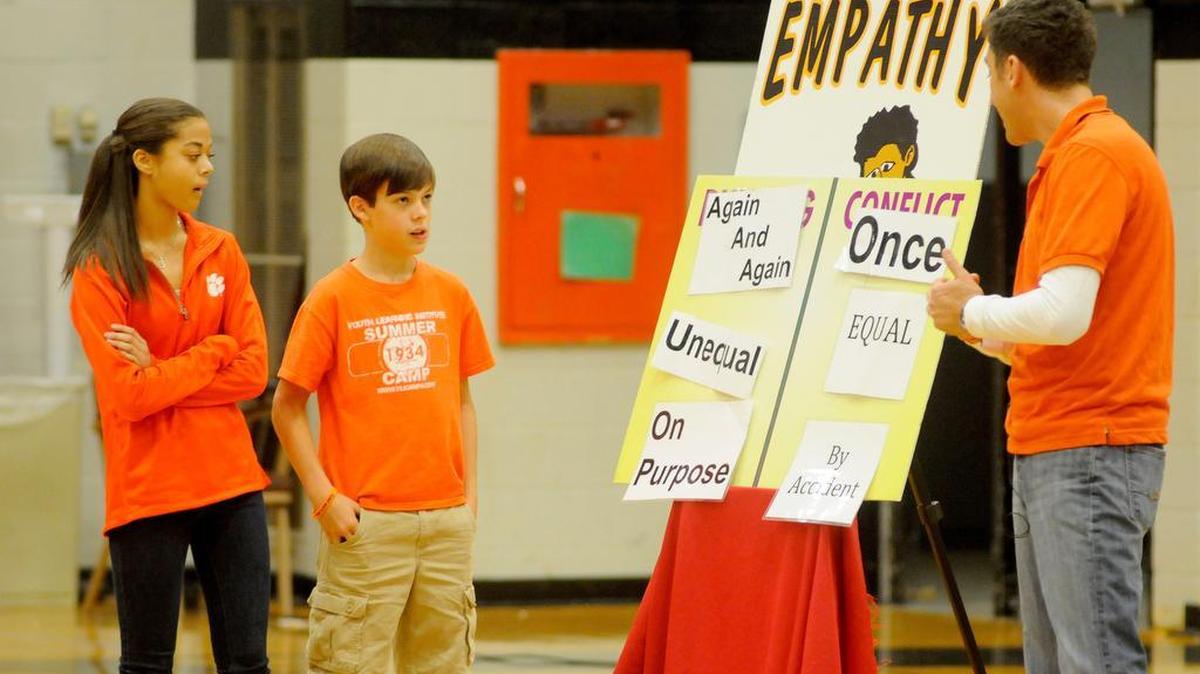 York Middle School eighth-grade students Brittany Rawlinson, left, and Coleman Coxe talk about the difference between conflict and bullying with presenter Jeremy Rubenstein during a Box Out Bullying presentation in the school gym.