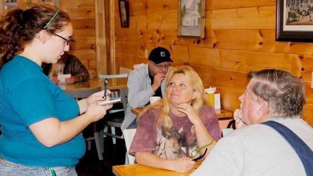 
Lauren McGill takes an order from customers Melissa Gerald Thomas at the Feedroom Grill at McGill’s General Store near Clover. McGill said the family has been fixing up the store for the past year to open the grill, with the aim of retaining the room’s historic character. 
