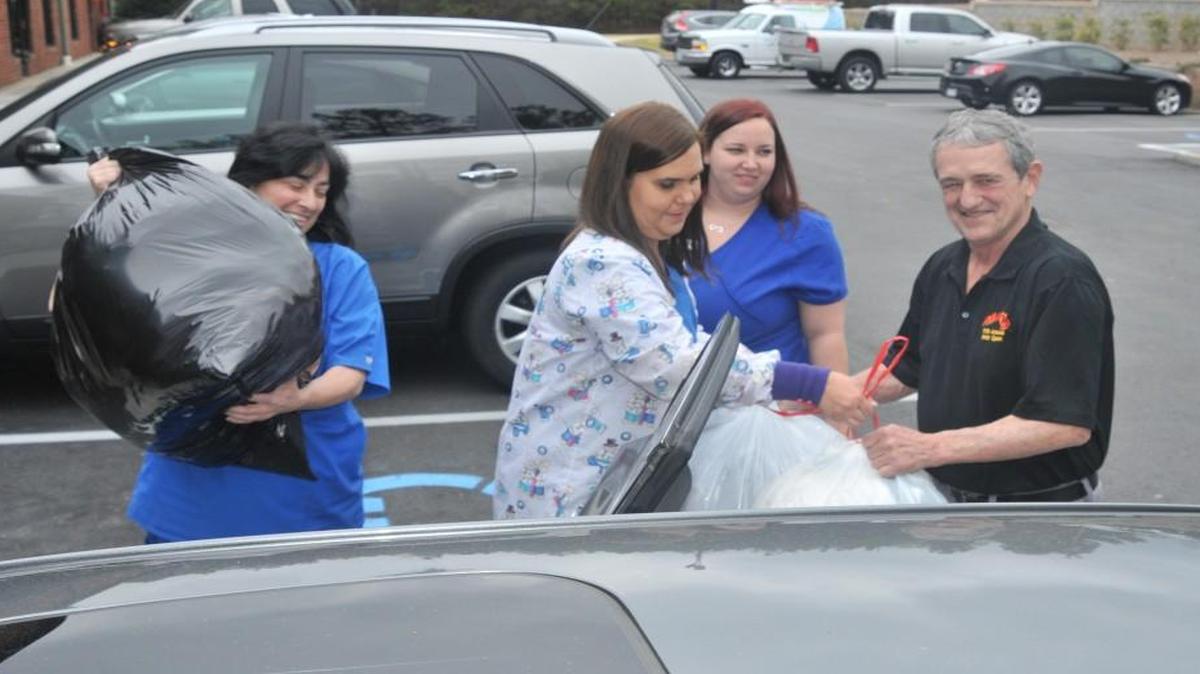 Jonna Moreschi, Jamie Burton and Ashley Black load coats and blankets into a car for Dean Cline, who delivered them to Pilgrims Inn.