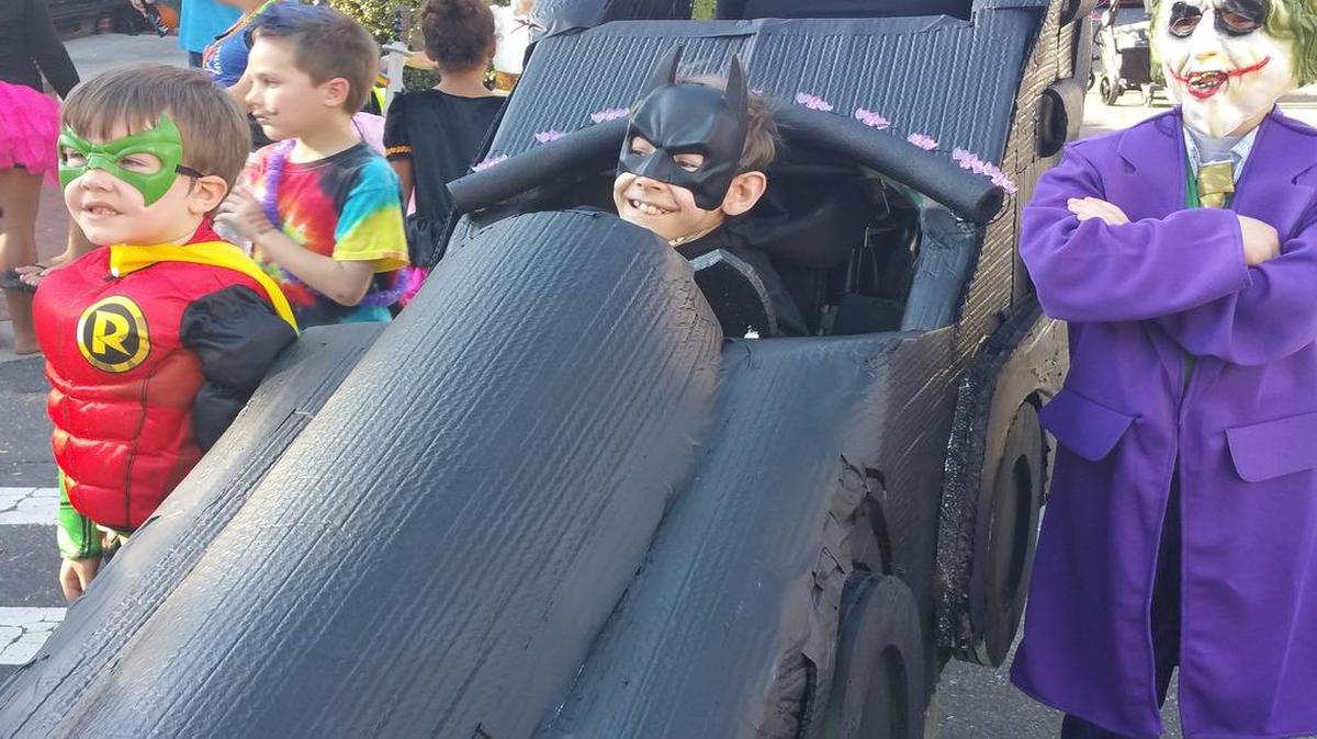 Steven Hollenbeck, 12, shows off his Batmobile Halloween costume built by a collaboration of the FM Boys & Girls Club and the FM art studio Chelsea and Savannah. Magic Wheelchair is a national nonprofit that builds "epic" costumes for kids in wheelchairs. Andy (left) and Darrel Earney round out the theme as Robin and Joker.