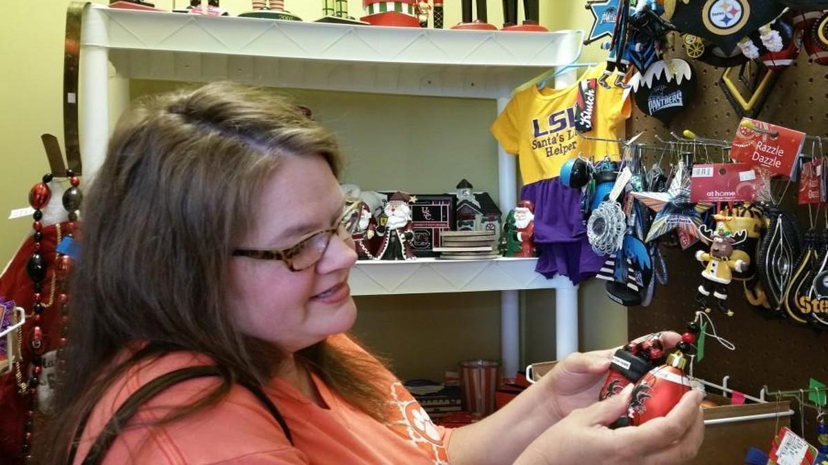 Regina Bryson of Fort Mill admires the handmade Nation Ford High School ornaments in the sports teams section at the HSYC's Christmas Shop. The shop is open until Christmas Eve.