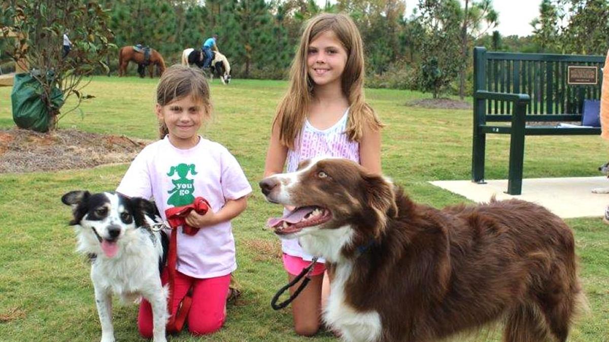 Kingsley, left, and Mary Heart, with their dogs Toto and Goose, after receiving blessings from the Rev. Sally Franklin at the Mary Warner Mack Dog Park Oct. 25.